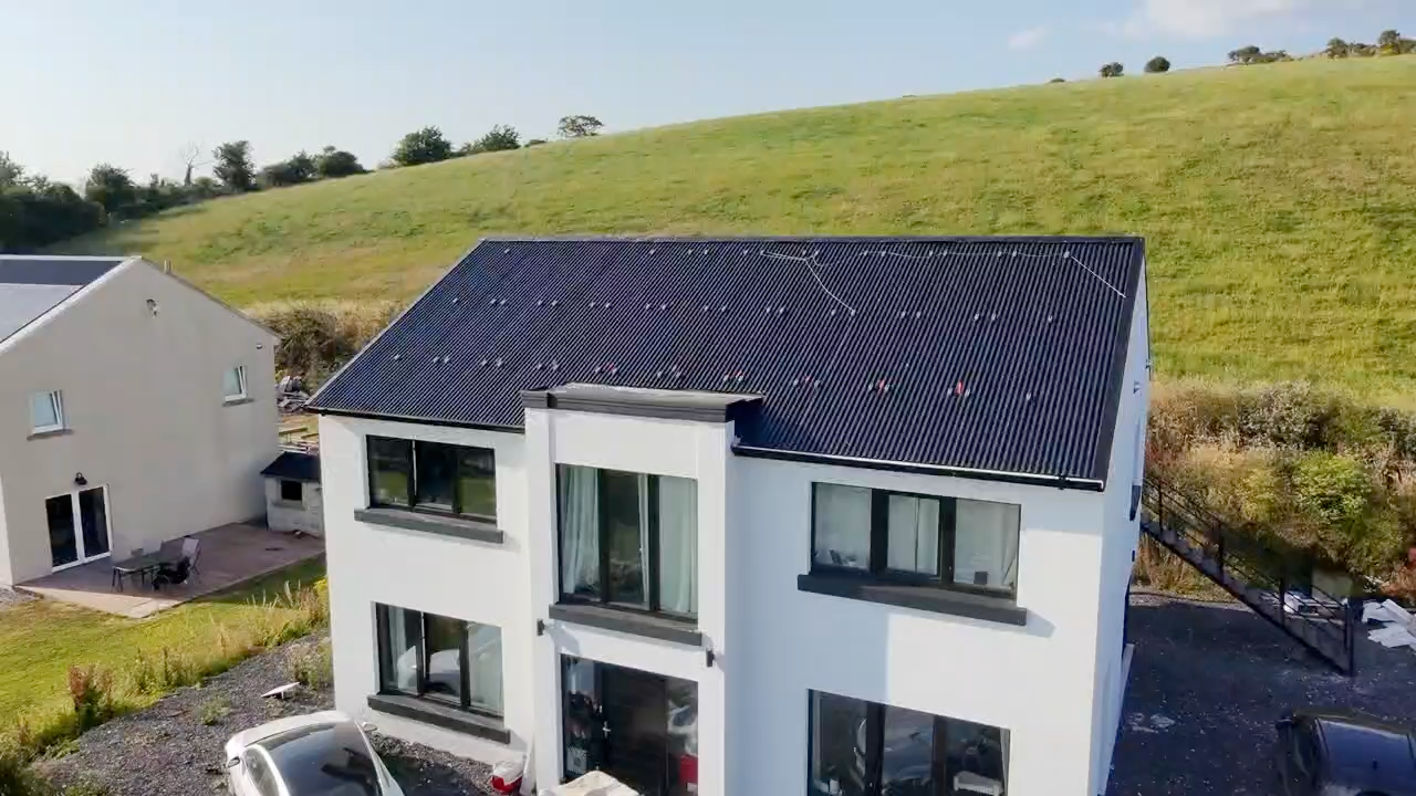Bespoke lightweight roof on a two-storey rural home with dark corrugated finish